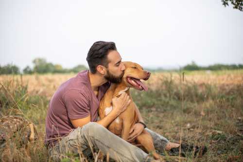 Ein Mann der seinen Hund umarmt und küsst